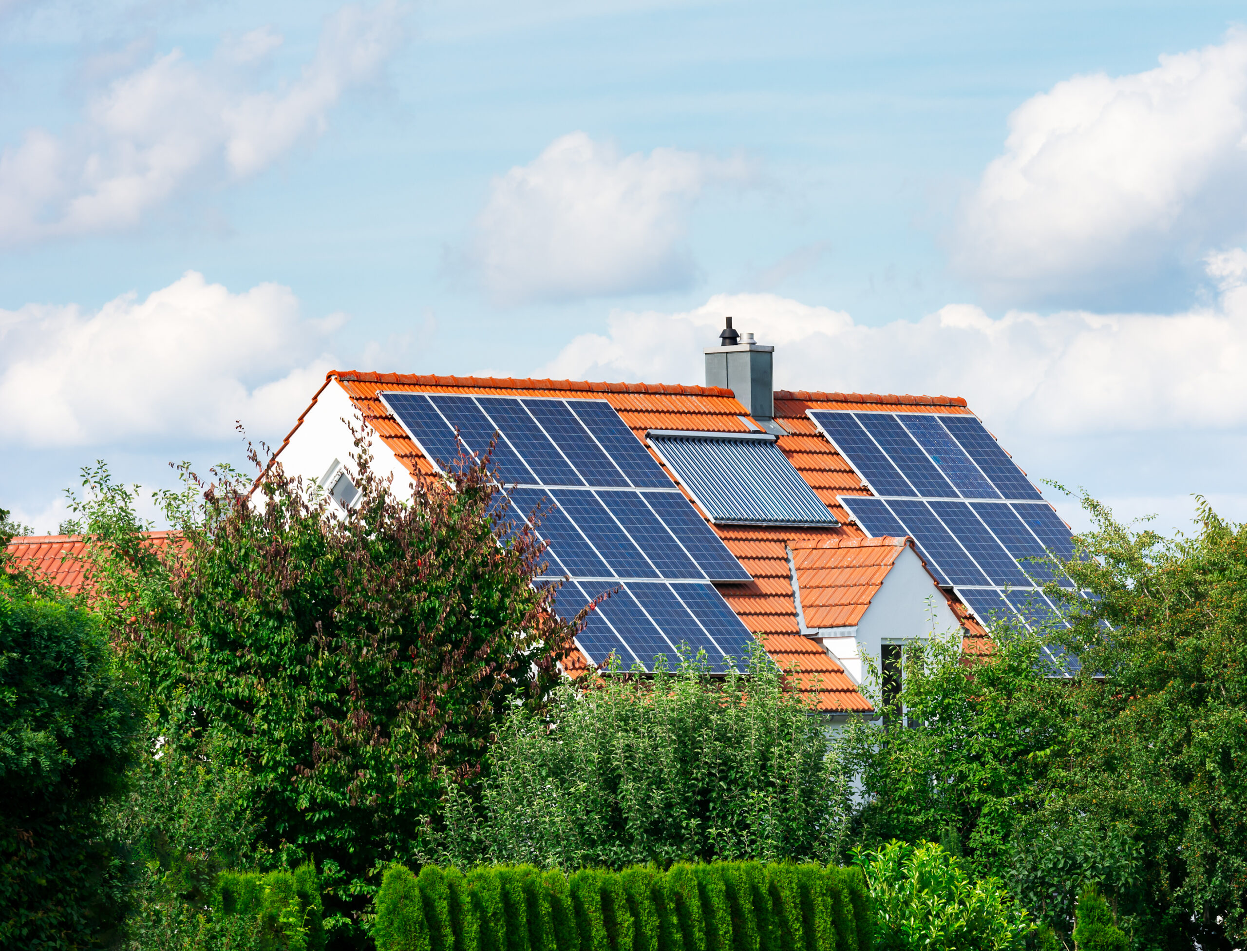 Modern house with photovoltaic solar cells on the roof and a thermal solar heating system for alternative energy production